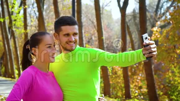 在秋日公园慢跑后一对运动情侣正在自拍视频的预览图