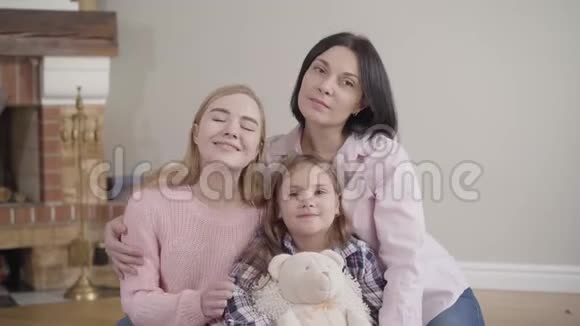 快乐的白种人黑发女人与两个可爱的女儿摆姿势的肖像年轻女子少女小可爱视频的预览图