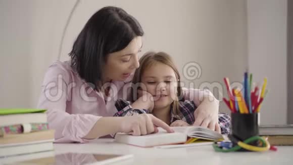 镜头接近白种人母女在一起读书女学生和妈妈在家看书母亲视频的预览图