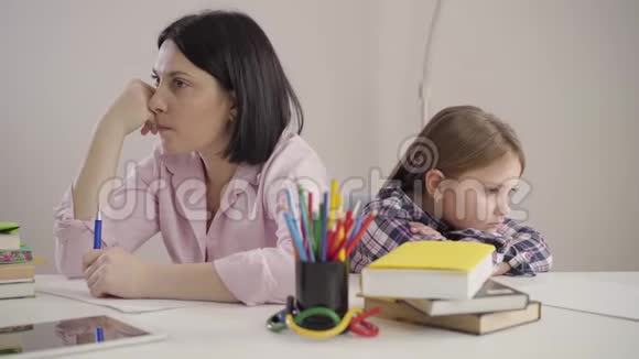 心烦意乱的白种人女人和女孩背靠背坐在桌子旁失望的母亲和悲伤的女儿争论说视频的预览图