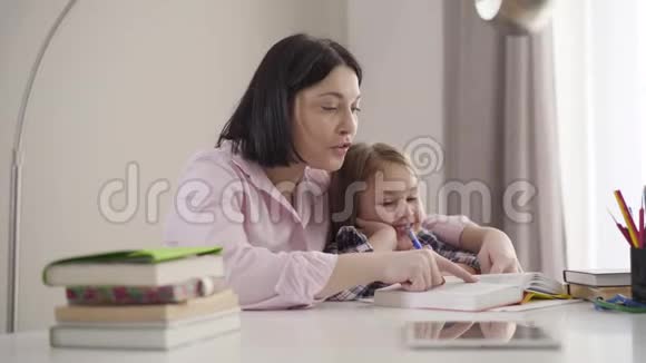 侧面看白种人母女在一起读书笑眯眯的快乐的女生读书快乐的妈妈视频的预览图
