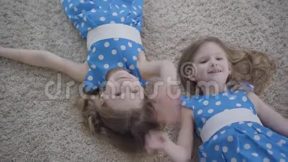 可爱的白种人女孩在镜头前挥手微笑快乐的黑发双胞胎姐妹享受着休息的乐趣视频的预览图