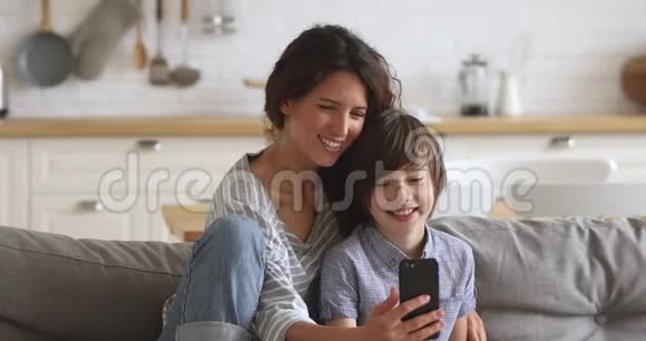 快乐的母亲和儿子在家里用智能手机笑视频的预览图
