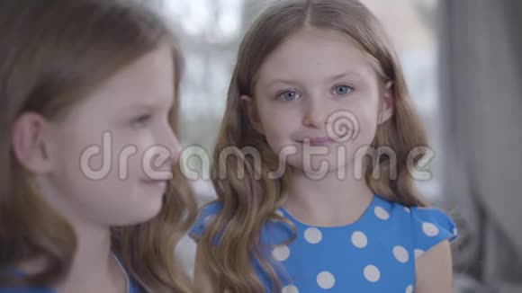 焦点的变化从微笑的小女孩的脸在背景到她的双胞胎姐妹的肖像在她的双胞胎姐妹在视频的预览图