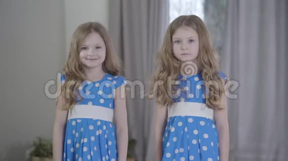 两个相同的双胞胎姐妹不同的气质类型在家里摆姿势快乐的女孩跳起来像她平静的兄弟姐妹视频的预览图