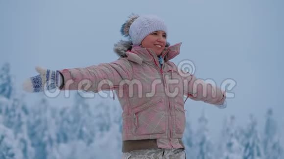 女人站在山顶上享受着奇妙的冬季北方景观视频的预览图