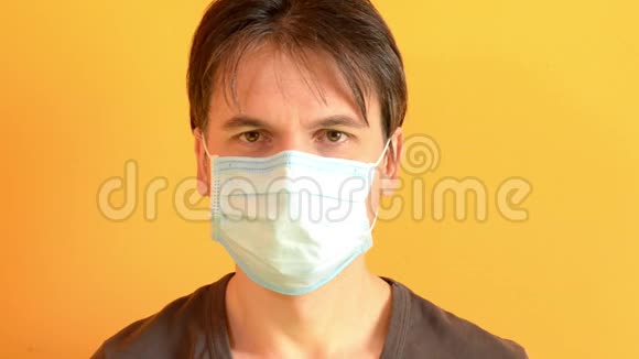 白种人冷静地放下医疗面具黄色背景病毒保护视频的预览图
