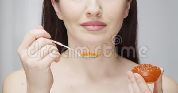 女人用银色勺子吃鱼子酱享受红色史诗中印第安的味道视频的预览图