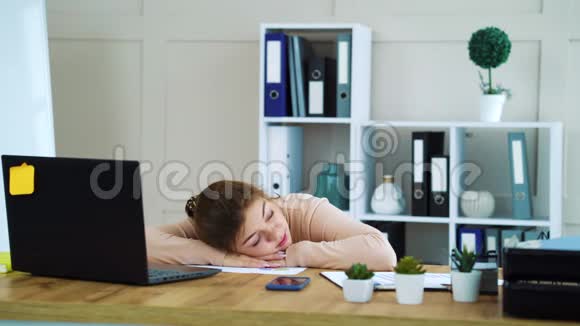 在办公室睡觉的女孩和同事在她的头上扔纸球视频的预览图