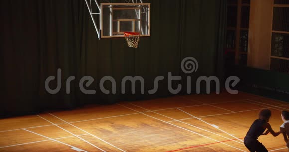 两名篮球运动员卷曲运球夜间比赛对抗的俯视图视频的预览图