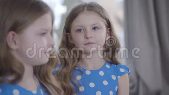 可爱严肃的白人女孩的头像灰色的眼睛看着镜头模糊的双胞胎姐妹的轮廓视频的预览图