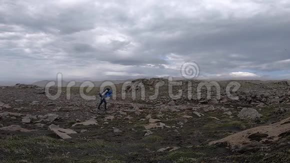在每秒30分的强风中年轻人几乎无法穿过冰岛崎岖的地形视频的预览图