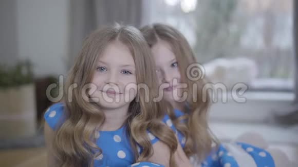 一幅美丽的白种人黑发女孩的肖像灰色的眼睛看着相机微笑着她的孪生妹妹视频的预览图