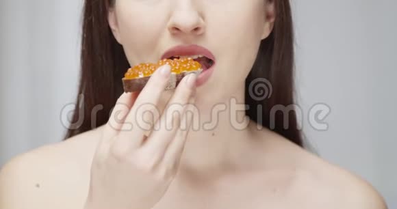 美丽的女性吃红鱼子酱的手工面包片让红色史诗上的味道消失视频的预览图