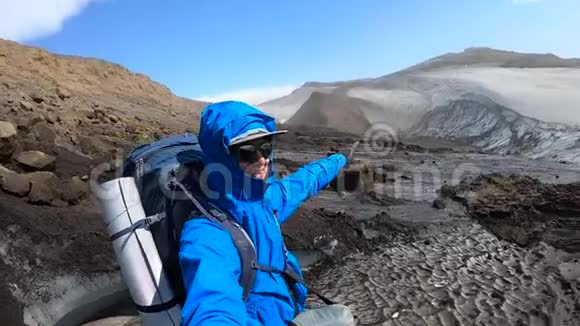 冰岛年轻的徒步旅行者在Fimmvorduhals徒步小径上指着冰川视频的预览图