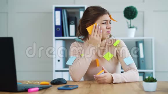 压力很大的女孩脸上粘着彩色贴纸办公室里的衣服视频的预览图