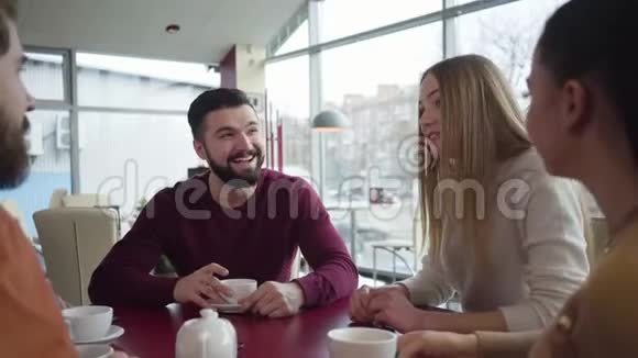 镜头移离餐桌与年轻的白种人朋友聊天金发迷人的女孩给同伴讲故事视频的预览图