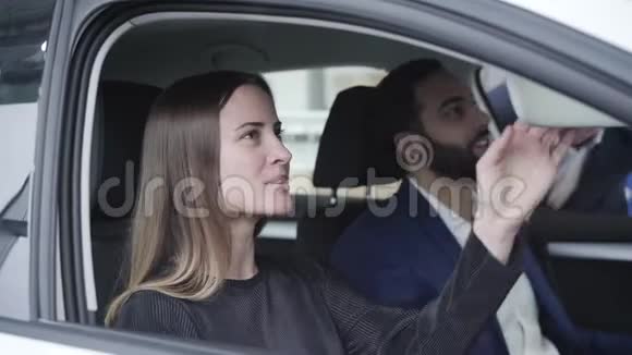年轻漂亮的白种女人坐在车里的副驾驶座上和中东男人和商人聊天妻子或视频的预览图