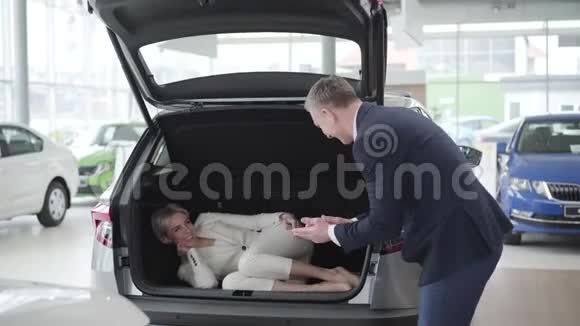 成年白种人男子打开汽车后备箱帮助开朗优雅的女人下车有钱的女商人视频的预览图