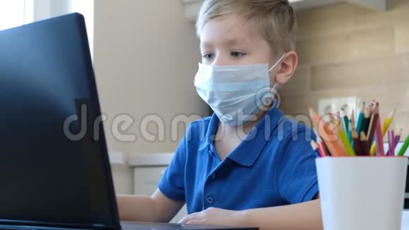 远程在线教育一个可爱的白人男孩在家做作业同时隔离了流行性冠状病毒视频的预览图
