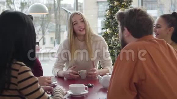 年轻的金发白种人女孩在餐馆和朋友交谈的肖像快乐的女人和一群人聊天视频的预览图