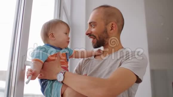 快乐的父亲抱着小儿子亲吻他拥抱和拥抱视频的预览图
