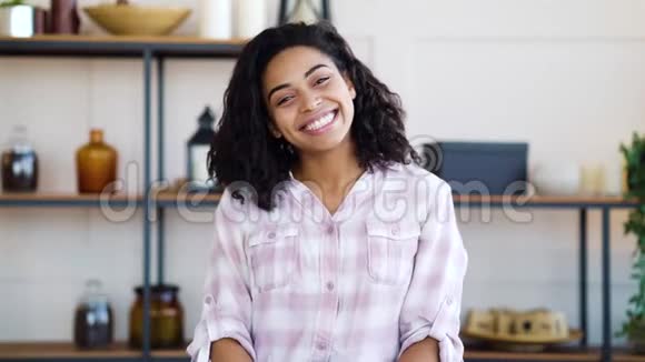 快乐的黑人女孩坐在家里对着镜头微笑视频的预览图
