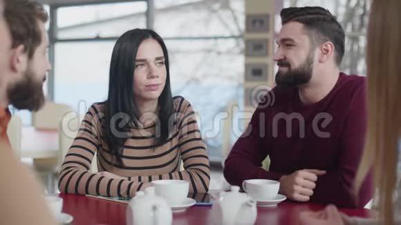 一对年轻的高加索夫妇在咖啡馆拥抱的肖像快乐的男人和女人和朋友坐在一起视频的预览图