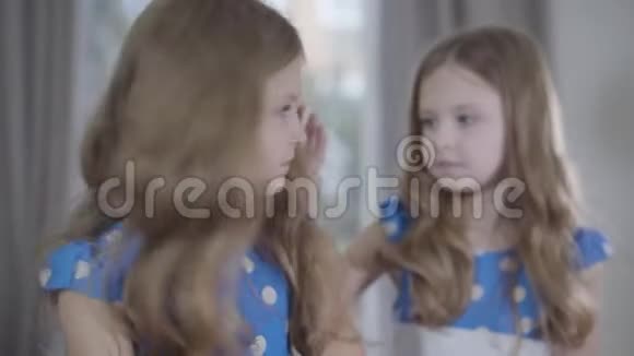 焦点的变化从前景悲伤的黑发女孩的脸到她可爱的双胞胎妹妹在后台抚摸的头视频的预览图