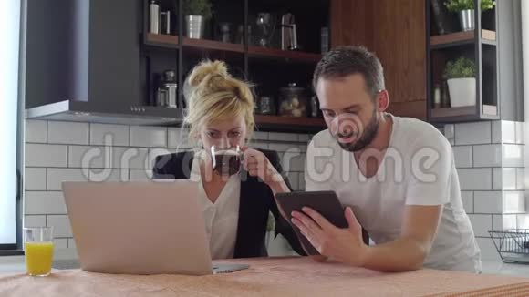 丈夫和妻子在厨房休息时上网视频的预览图