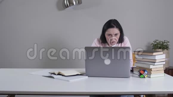 一幅被吸引的白人妇女用笔记本电脑作为无法辨认的男人走进来的照片紧张的妻子或母亲关闭装置视频的预览图