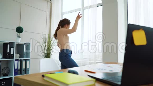 年轻女企业家在工作休息期间在办公室窗口跳舞视频的预览图