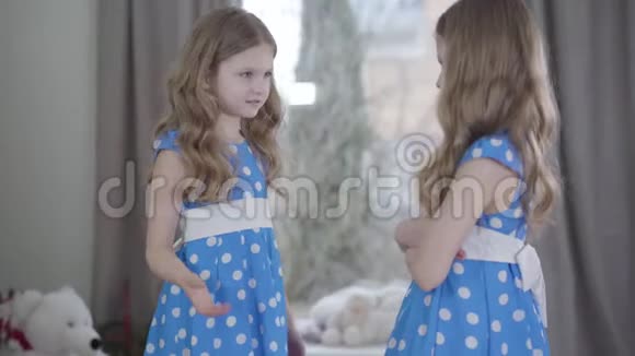 在室内争吵的白种人双胞胎的侧面两个穿着漂亮衣服的同父异母的姐妹吵架视频的预览图