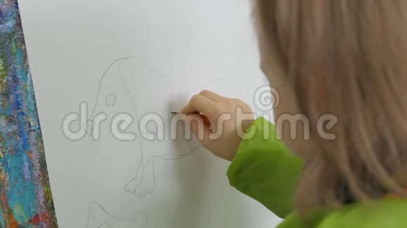 一个小女孩正坐在画架上画一只狗在纸上视频的预览图