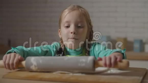 可爱的小女孩用擀面杖擀面团视频的预览图