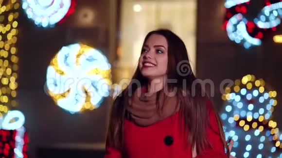 可爱的女孩走在装饰着圣诞灯的展示柜上视频的预览图