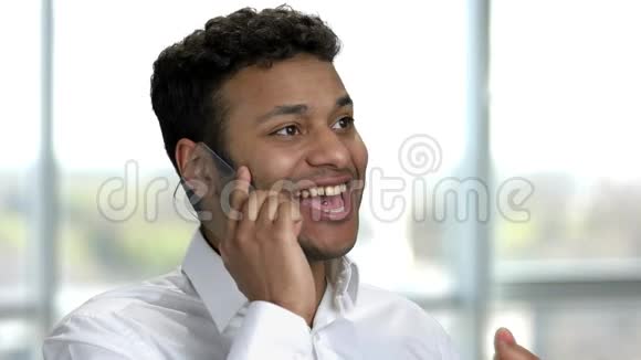 描绘了一个非常幸福的年轻印度男人在copyspace电话上交谈视频的预览图