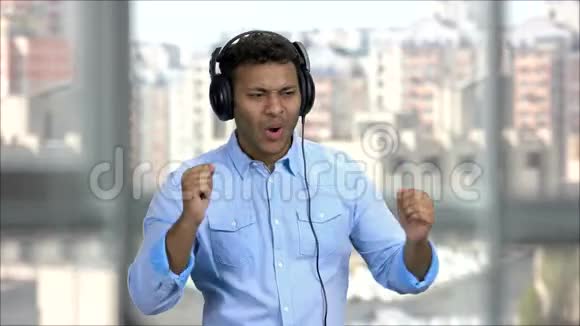 印度男人带着耳机欣赏音乐视频的预览图
