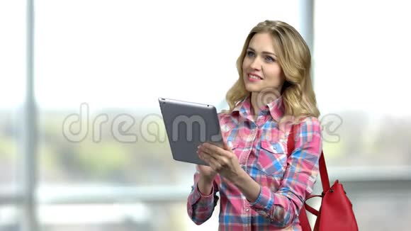 金发性感女孩带钱包使用数字平板电脑视频的预览图