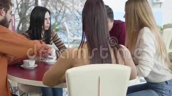 摄像机围绕着五个白人朋友坐在咖啡馆里聊天快乐的男人和女人在餐厅休息视频的预览图