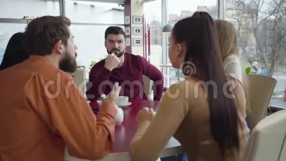 愤怒的白人男女在阳光明媚的日子在咖啡馆里争吵一群朋友在餐馆里互相冲突有胡子的人视频的预览图