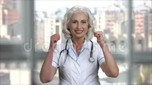 戴着医用外套和听诊器的高级医生女士竖起大拇指视频的预览图