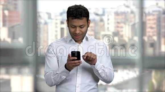 印度年轻人在办公室用智能手机娱乐社交媒体视频的预览图
