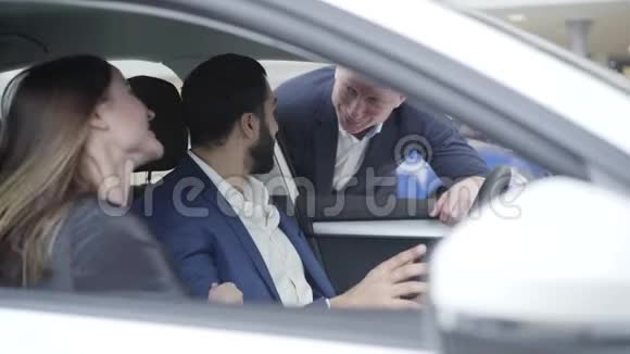 布鲁内特高加索女人把头放在中东男人的肩膀坐在汽车上微笑富有视频的预览图