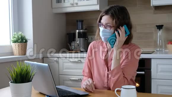 戴着医用口罩的女人在家里工作科罗纳病毒检疫隔离期视频的预览图