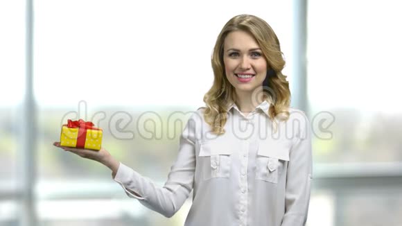 年轻性感女人拿着红色丝带的黄色礼盒的肖像视频的预览图