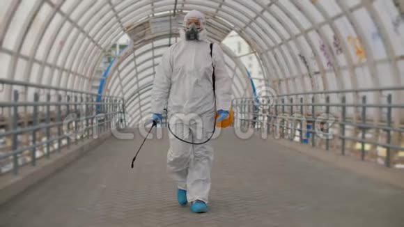 穿着防护制服的消毒工人病毒学家穿过立交桥视频的预览图