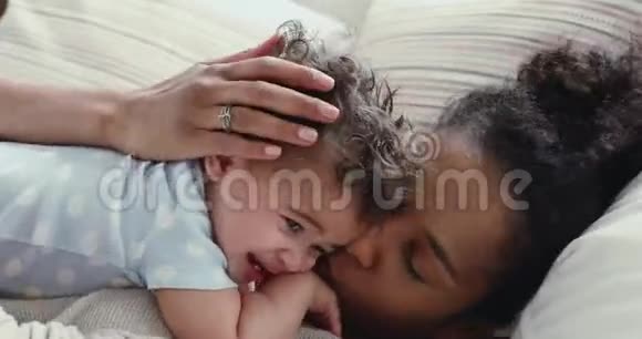 可爱的非洲妈妈拥抱在床上的可爱的小男孩视频的预览图