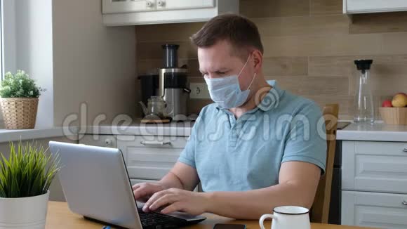 戴着医用口罩的人在家里工作科罗纳病毒检疫隔离期视频的预览图