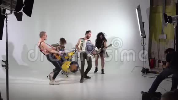 拍了一个朋克摇滚乐队的片段一个摄影师在工作音乐家们正在用乐器跳跃低音视频的预览图